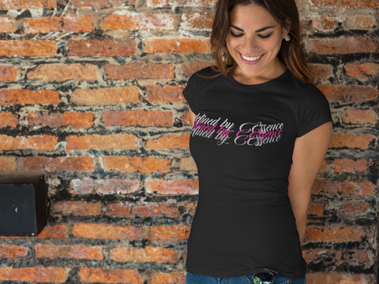 Women wearing black 3d Defined By Essence T- Shirt with multilayering wording standing against a wall.