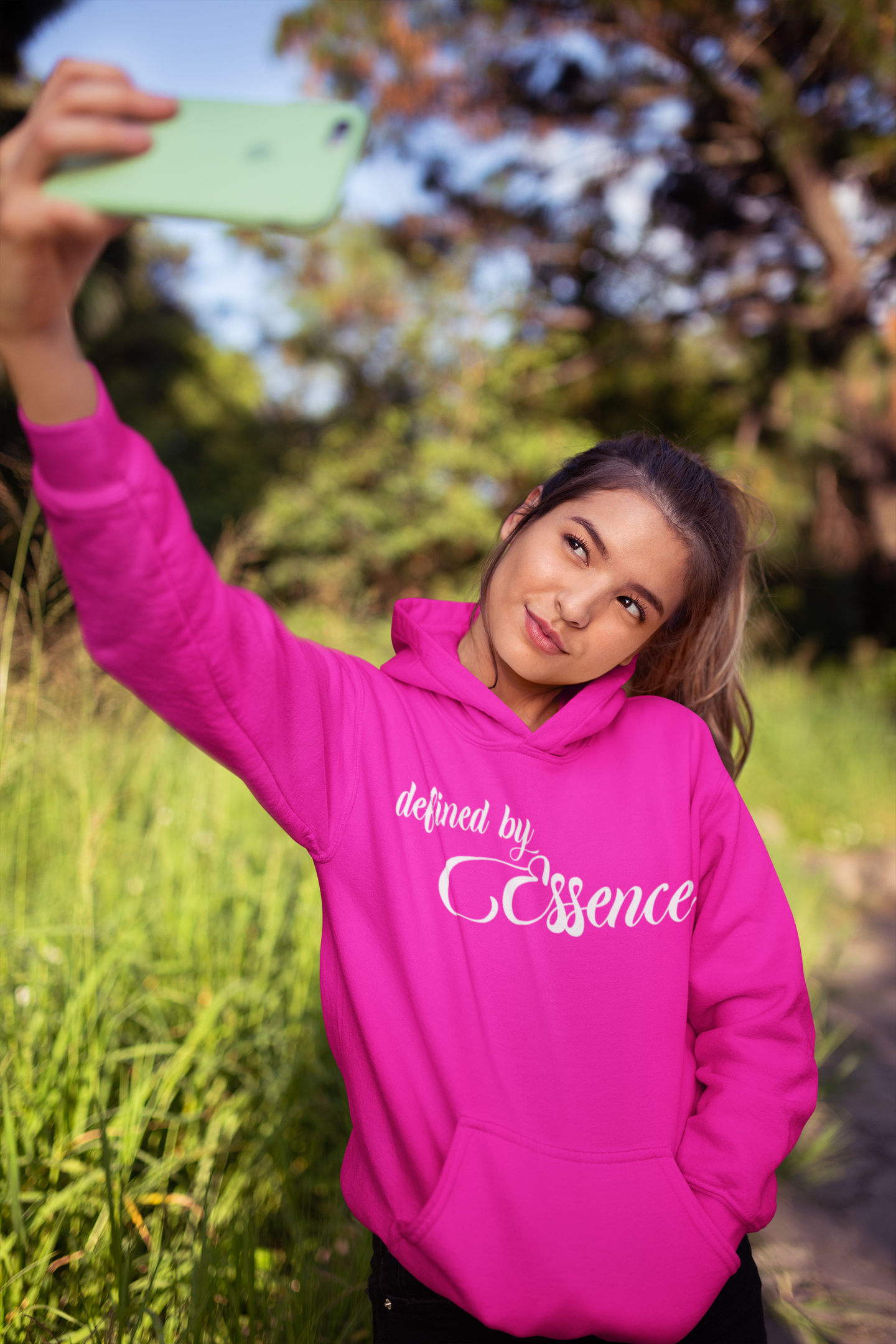 Women wearing a pink signature Defined by Essence hoodie during a cool day outside.