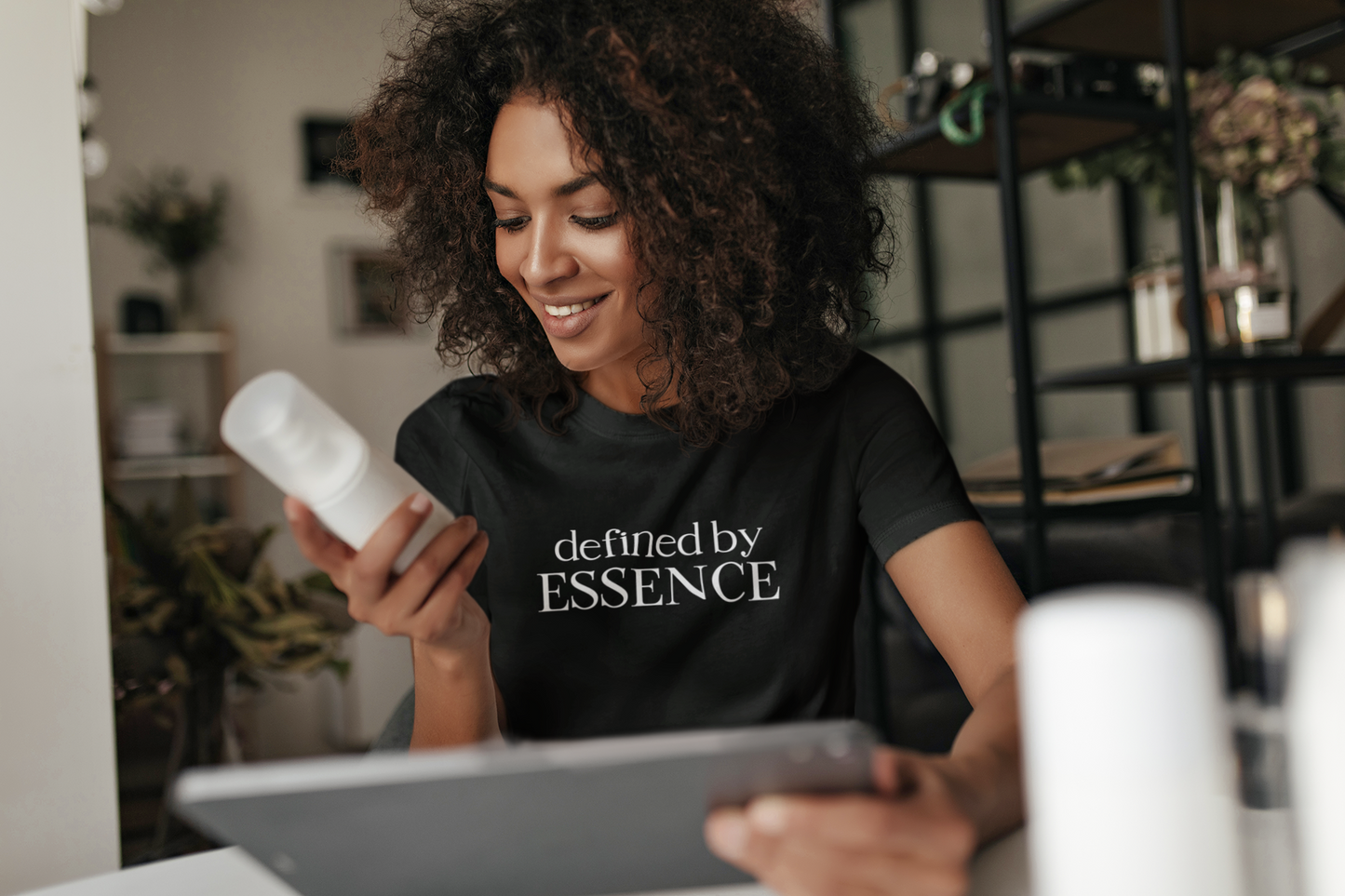 Women wearing a black Defined By Essence T-Shirt looking at a product
