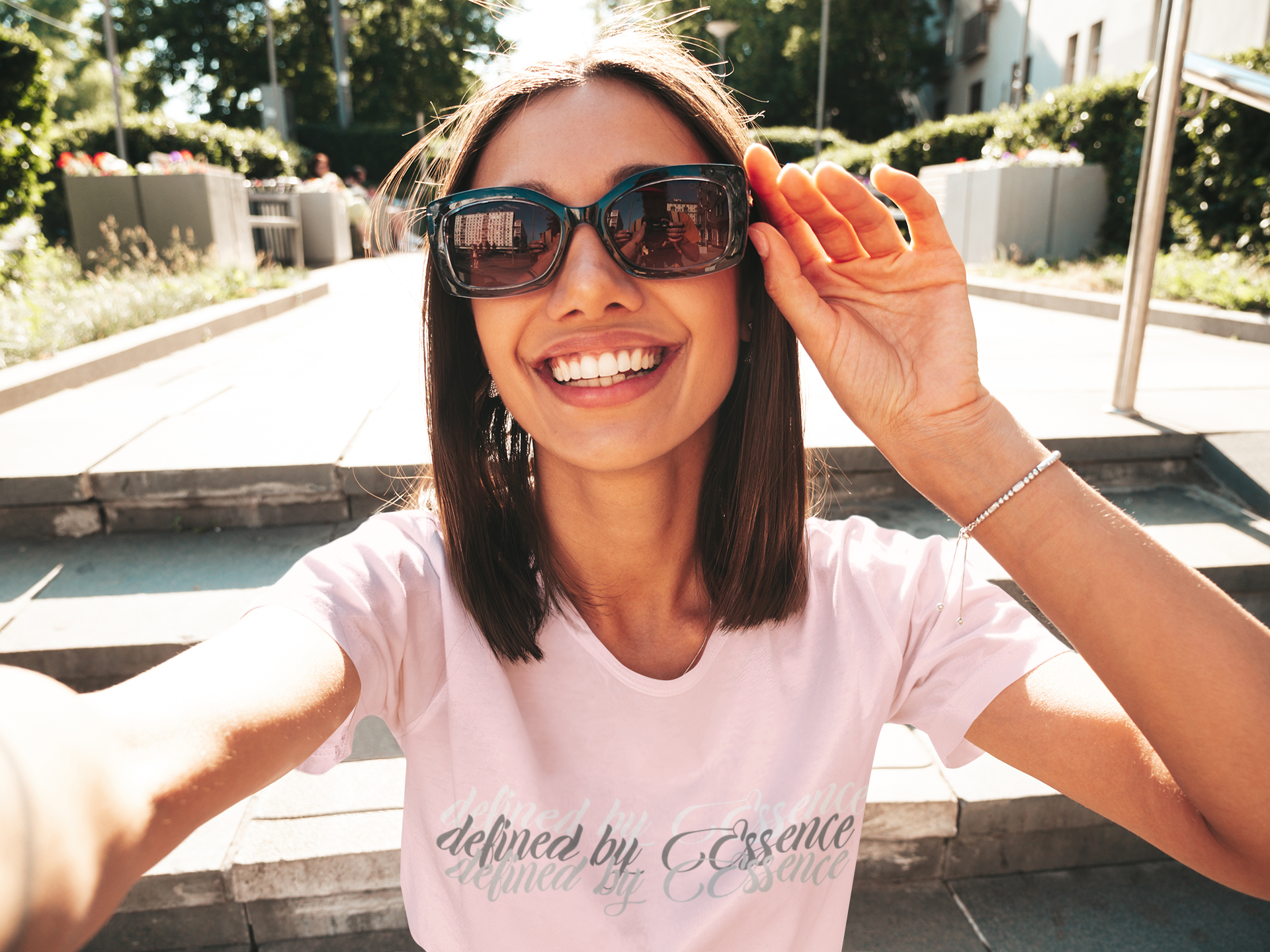 Women wearing a light pink 3d Defined By Essence T- Shirt with multilayering wording enjoying the day outside.