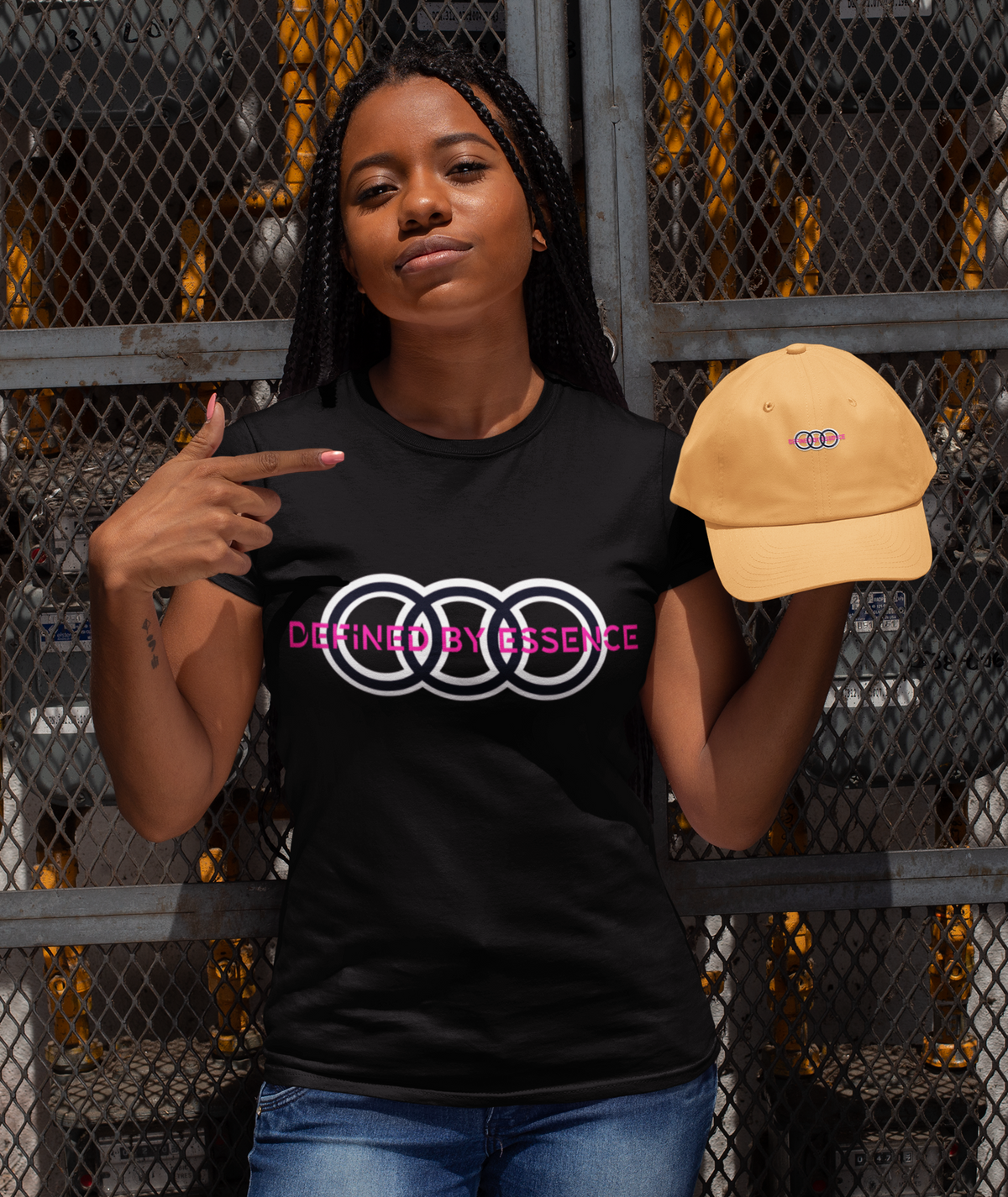 Women wearing a black Infinite Signature Defined By Essence T-Shirt modeling with a dad hat.